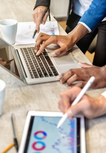 Crop businesspeople using gadgets in office