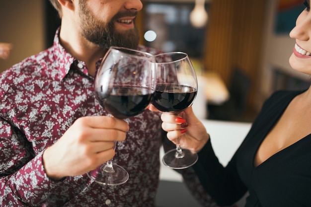 Crop cheerful couple celebrating with wine