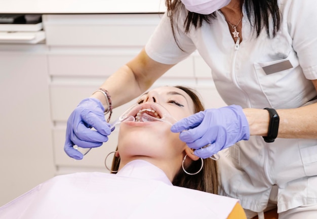 Crop dentist examining teeth of patient