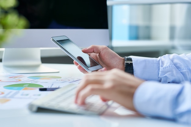 Crop entrepreneur with smartphone at workplace