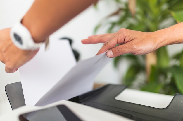 Photo crop hands taking paper from printer