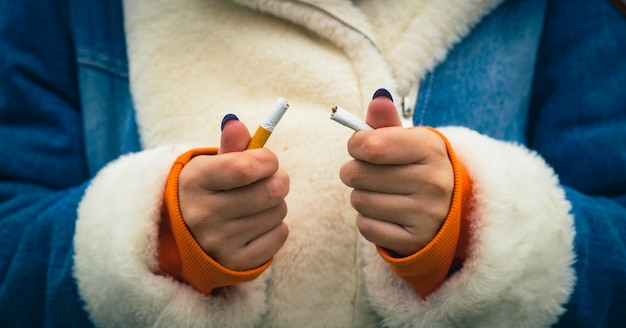 Crop woman breaking cigarette and quitting smoking Closeup of crop woman splitting cigarette for idea of stop smoking