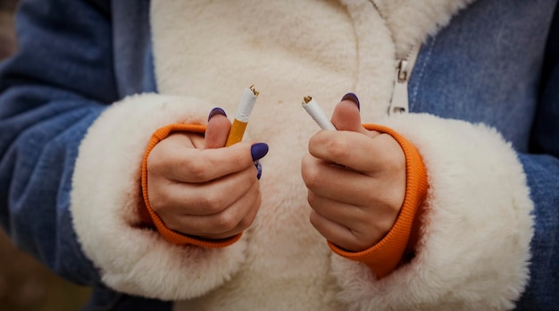 Crop woman breaking cigarette and quitting smoking Closeup of crop woman splitting cigarette for idea of stop smoking