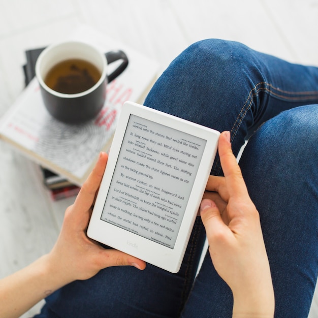 Crop woman reading e-book