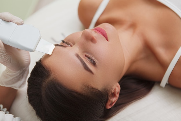 Cropped close up of a gorgeous young woman getting ultrasound facial at dermatology salon