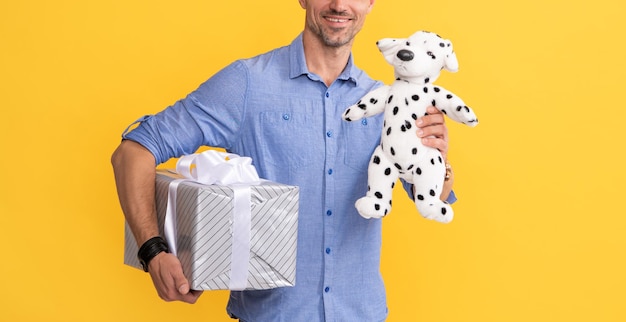 Photo cropped guy with gift box and toy on yellow background purchase