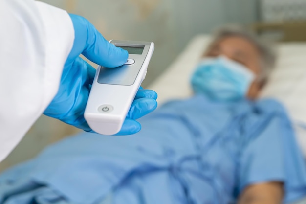 Photo cropped hand of doctor examining patient lying on bed