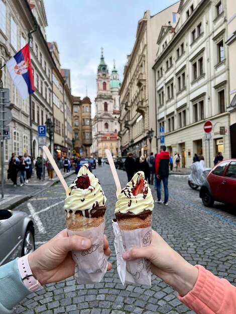 Cropped hand holding ice cream cone in city