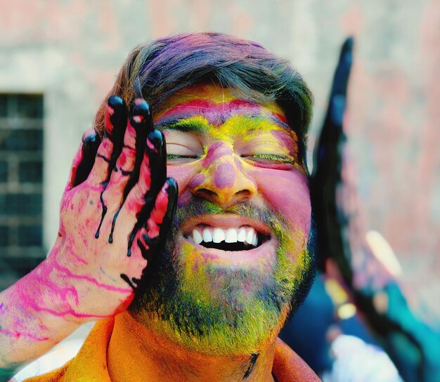 Photo cropped hand of person applying powder paint on smiling man face