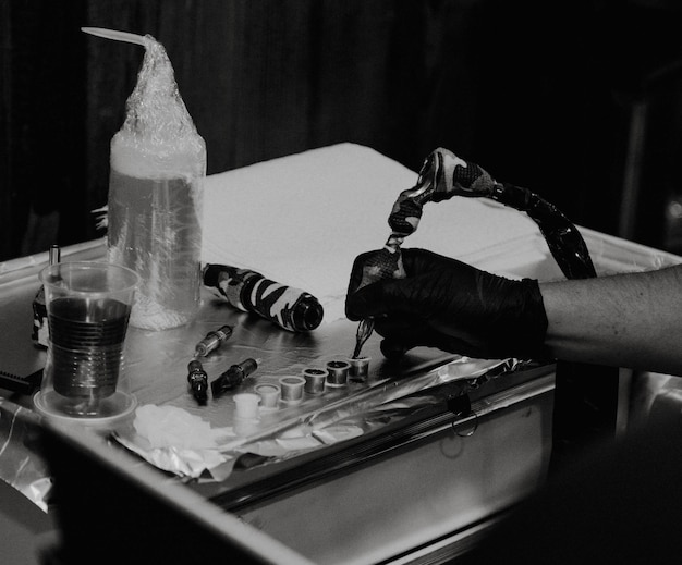 Cropped hand of tattoo artist holding work tool in workshop