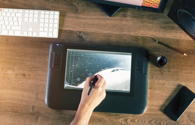 Cropped hand using graphics tablet on table