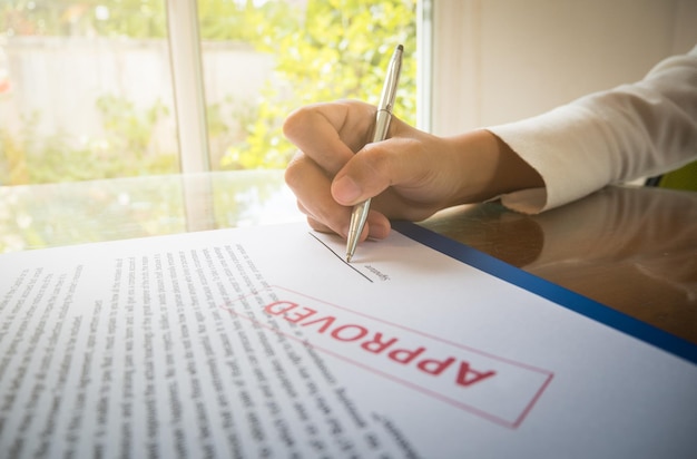 Photo cropped hand of woman signing on document