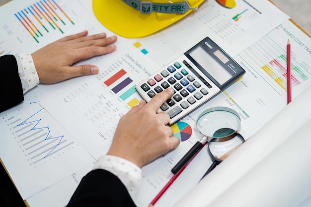 Photo cropped hands of businesswoman analyzing graphs on desk