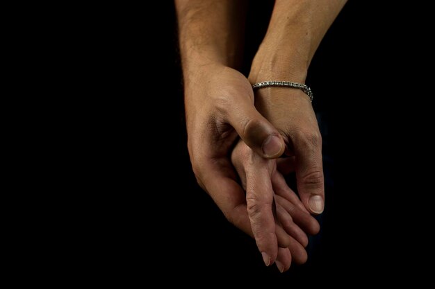 Cropped hands of couple against black background