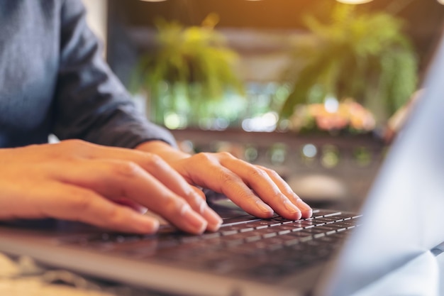 Photo cropped hands of person using laptop on table