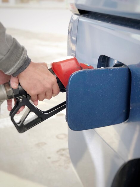 Photo cropped hands refueling car at gas station