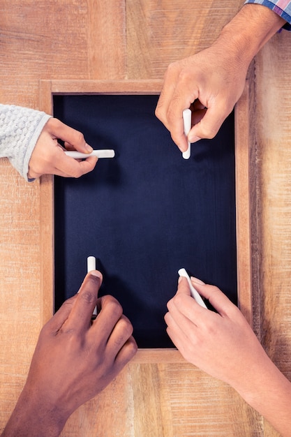 Cropped hands writing on slate at creative office