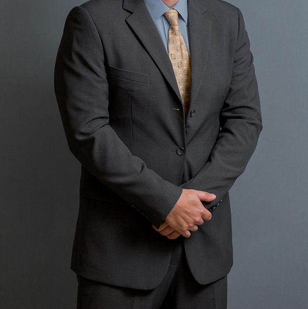 Photo cropped head man standing in a smart suit with hands together