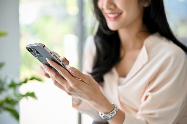 Cropped image of an attractive millennial Asian businesswoman using her smartphone