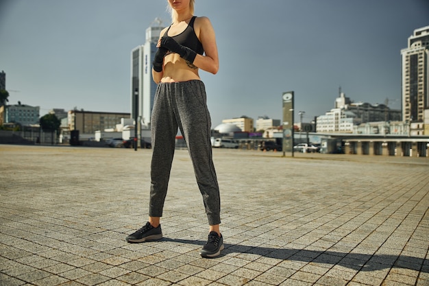 Cropped image of  beautiful athletic female with black hand wraps for boxing gloves