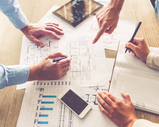 Cropped image of business people working with documents.