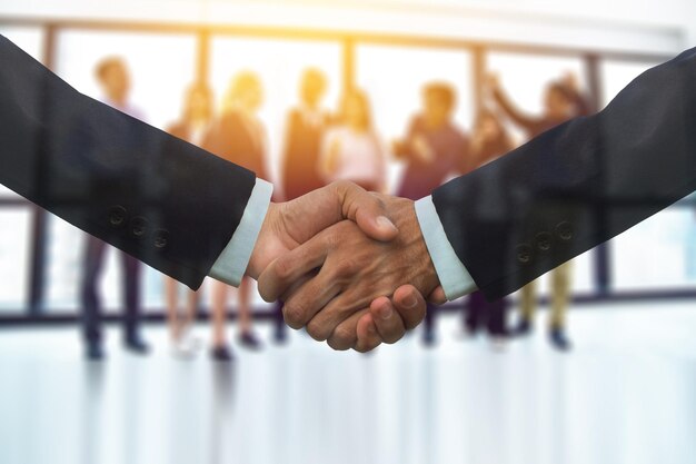 Cropped image of colleagues shaking hands in office