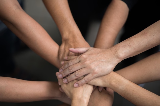 Cropped image of friends stacking hands