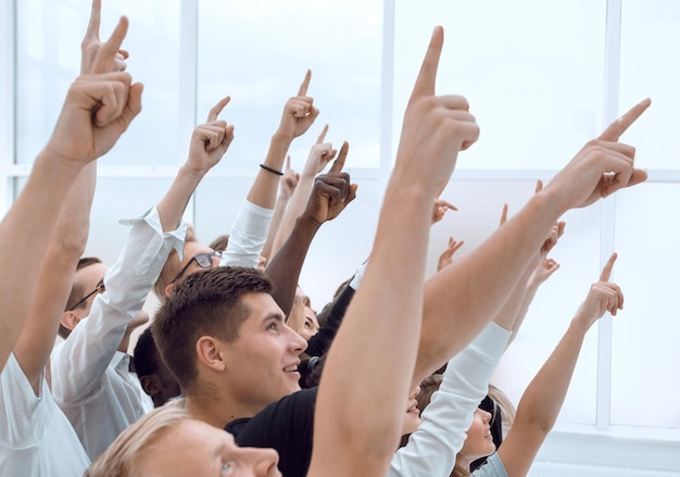 Cropped image of a group of young people pointing up