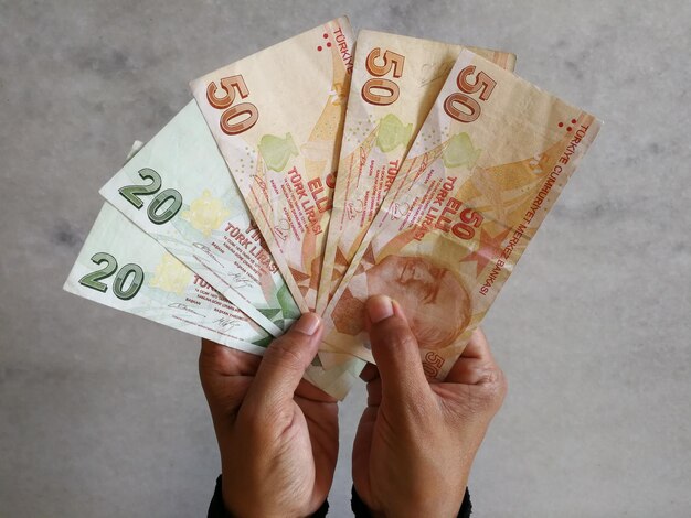 Photo cropped image of hands holding turkish lira currency