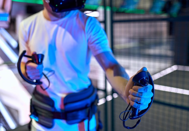 Cropped image of handsome young man with glasses of virtual reality. VR, games, entertainment, future technology concept.