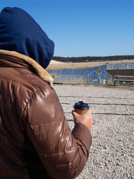 Cropped image of man holding cup of takeout coffee