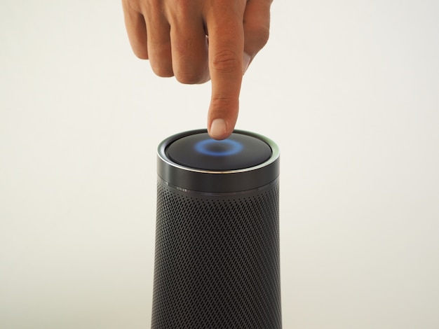 Cropped image of a man using a speaker with artificial intelligence voice assistant and touch technology.