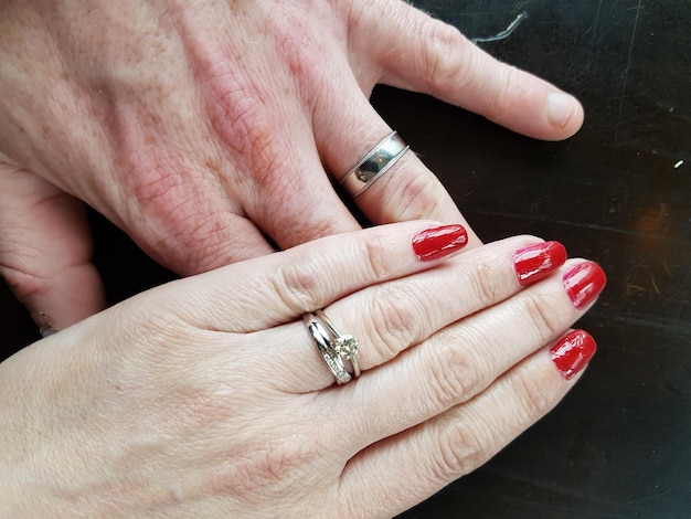 Photo cropped image of married couple with wedding ring on table