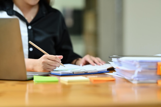 Cropped image of professional businesswoman writing business strategy signing a contract at