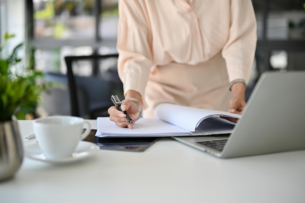 Cropped image a professional and busy Asian businesswoman focusing on examining a financial report