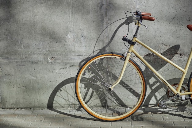 Cropped image of stylish vintage bicycle standing in the outdoors isolated on grey wall