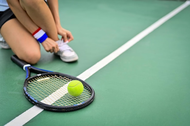 Cropped image of tennis player tying shoelace on court getting ready for match Sport active life competition concept