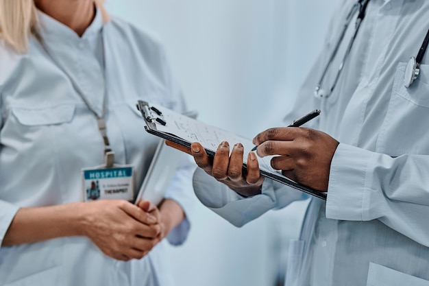 Cropped image of two doctors writing information on forms Background