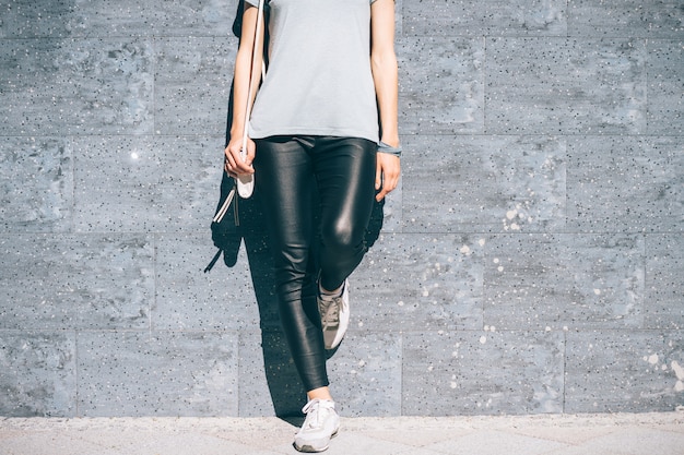 Cropped image of a woman in black pants and a blue T-shirt