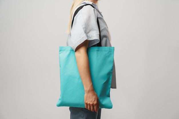 Cropped image of woman holding color shopping bag in studio