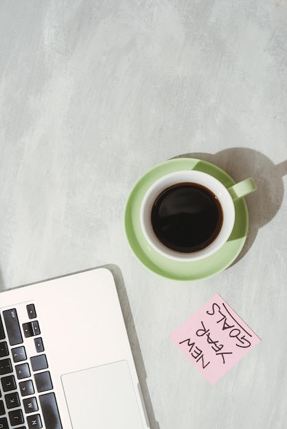 Cropped image of woman holding paper sticker with word ideas near laptop