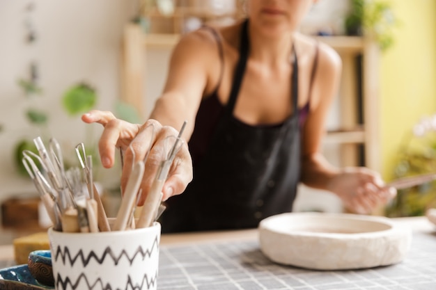 Cropped image of a woman making ceramic and pottery tableware at the workshop