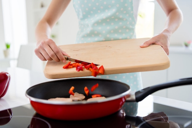 Cropped photo of housewife hands holding cutting wooden board checking meat condition adding fresh pepper cooking tasty dinner white light kitchen indoors