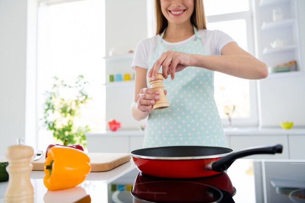 Cropped photo of pretty housewife hands holding salt adding mixing frying pan ingredients cooking tasty dinner preparation family meeting white light kitchen indoors