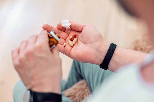 Cropped photo of unrecognized person shaking a glass bottle and putting pills into his hand