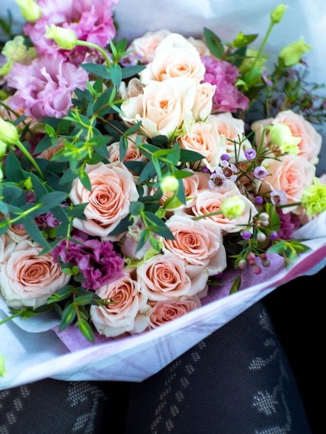 Cropped picture of Woman legs with rose bouquet selective focus