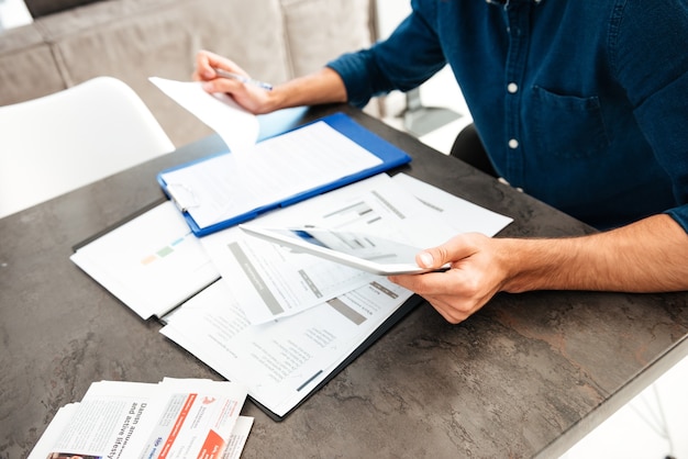 Cropped picture of young man's hands holding documents