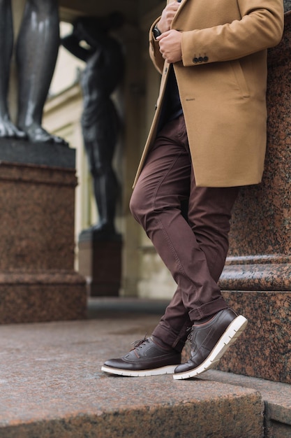 Cropped portrait of unrecognizable handsome man in elegant autumn beige coat