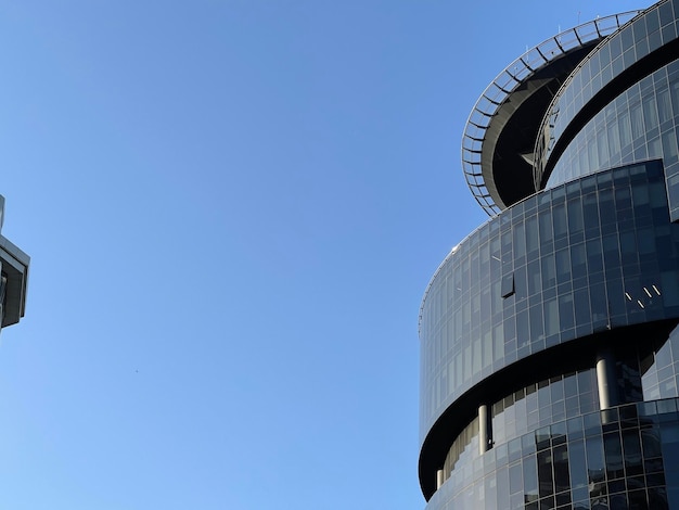 Cropped shot of a black glass skyscraper under blue sky