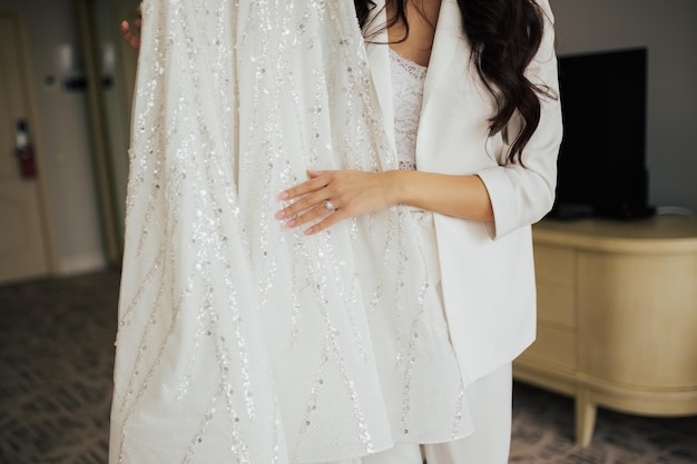 Cropped shot of bride who touches wedding dress